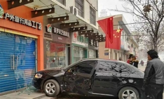 御驾街一辆黑色轿车冲上人行道将一家店铺的玻璃门撞碎